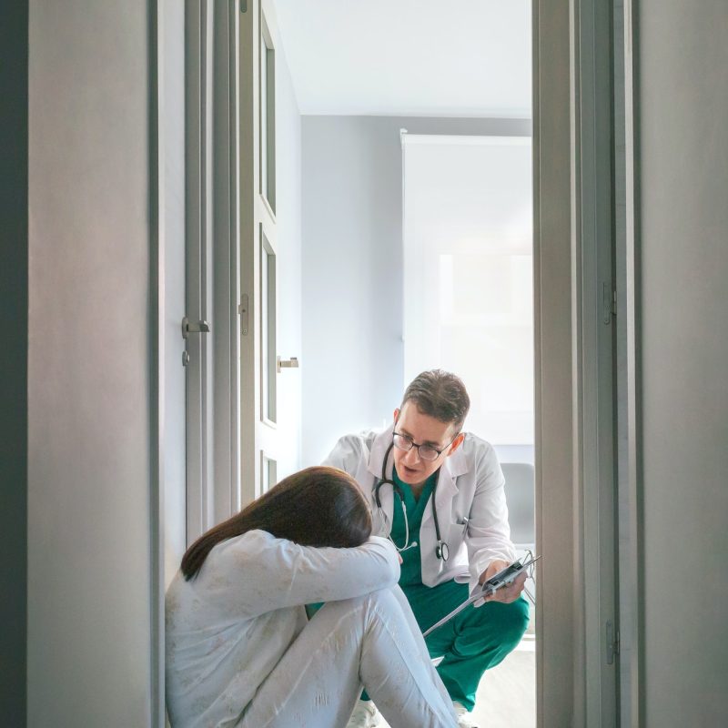 psychiatrist-talking-to-patient-sitting-on-the-floor-in-a-mental-health-center.jpg